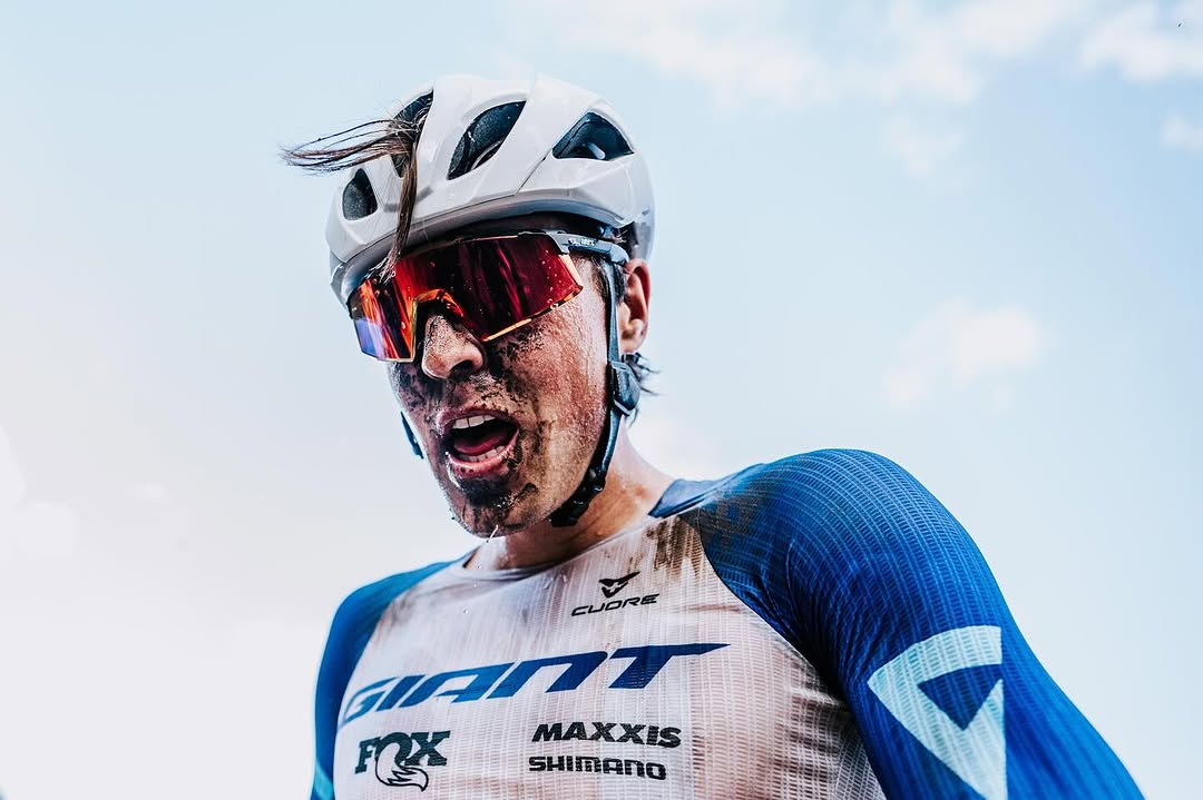 Carter Woods close-up portrait in Giant team kit, muddy face after a race
